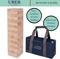 Houten stapeltoren met blauwe draagtas met 'Tumble Tower' opschrift. "Excl. kwaliteit houten blokken" en "Superieure kwaliteit draagtas".