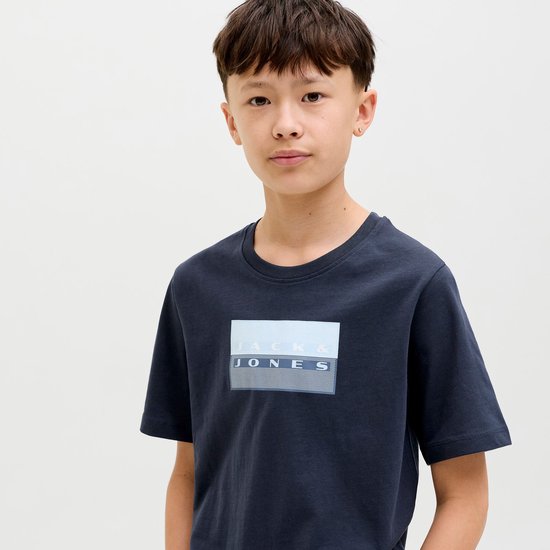 Jongens in een donkerblauw T-shirt met "JACK & JONES" opdruk.