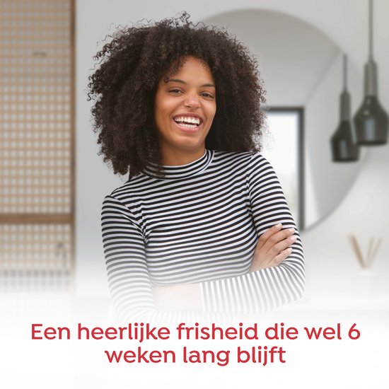 Vrolijke vrouw met afro haar, lacht en draagt zwart-wit gestreept shirt. 'Een heerlijke frisheid die wel 6 weken lang blijft'.