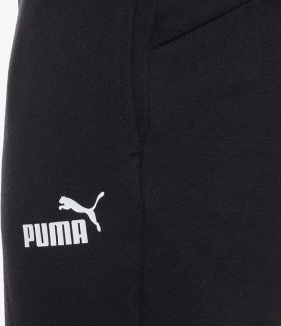 Close-up van het witte PUMA logo en de tekst PUMA op een zwarte sweatbroek.