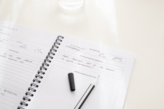 Open notitieboek met pen, met ingevulde tekst over een activiteit.