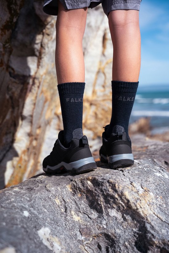 Kinderen met donkerblauwe Falke sportsokken, zichtbaar vanaf de kuiten tot boven de schoenen.