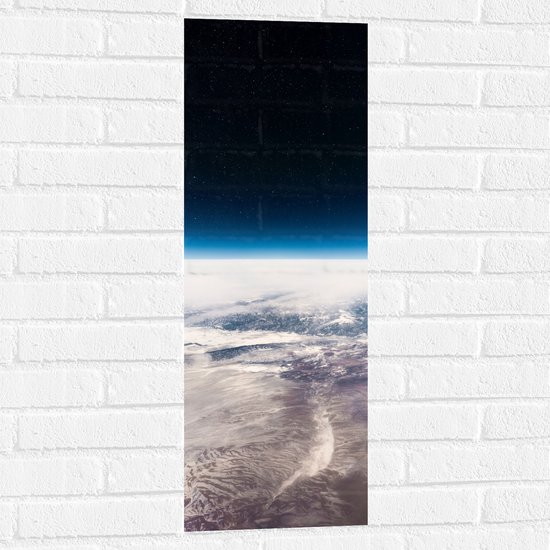 WallClassics - Muursticker - Uitzicht over de Aarde in de Ruimte - 30x90 cm Foto op Muursticker