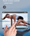 Vrouw met touch screen control van de actiecamera, terwijl ze traint op het strand.