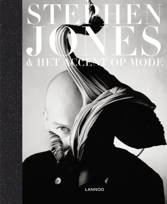 Zwart-wit cover van het boek 'Stephen Jones & Het Accent Op Mode'. Een kaalgeschoren man kijkt intens, met een gestreept, geplooid textiel voor zijn gezicht.
