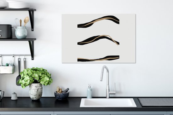 Canvas met drie abstracte, golvende lijnen in het zwart en goud op een witte achtergrond.