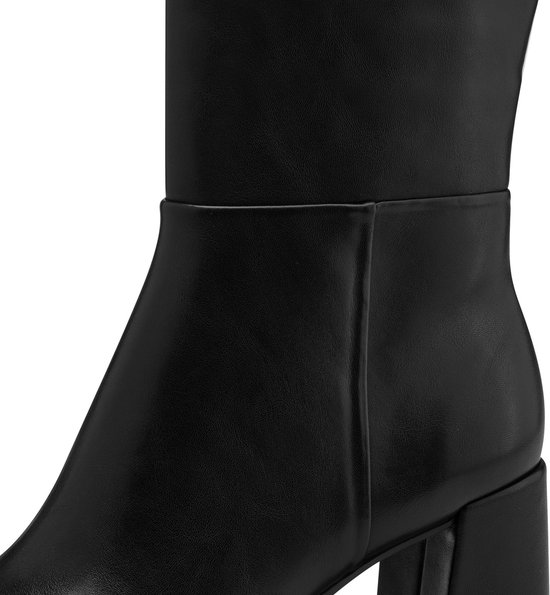 Détail de la tige et du talon d'une botte en cuir noir avec fermeture éclair.