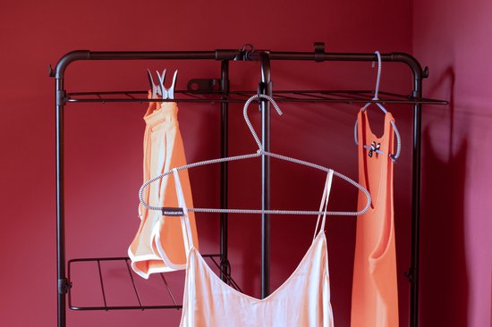 Bovenaanzicht van de zwarte droogtoren met oranje kledingstukken en een gestipt hemdje.