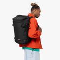 Man met een zwarte Eastpak rugzak op zijn rug.