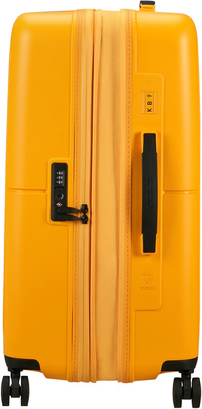 Gele American Tourister koffer met zwarte handgreep en TSA-slot.