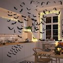 Cuisine décorée avec 140 autocollants chauve-souris noirs volant tout autour, avec des lumières et des citrouilles.