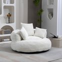 Witte fauteuil met vier kussens, zachte rondingen, in een woonkamer.