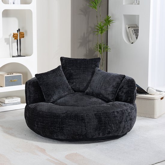Donkergrijze, ronde fauteuil met vierkante kussens, in een woonkamer.