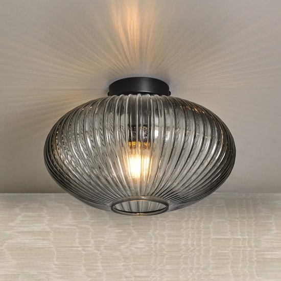 Ronde plafondlamp van geribbeld smokeglas met een zwarte houder, gemonteerd aan een plafond.