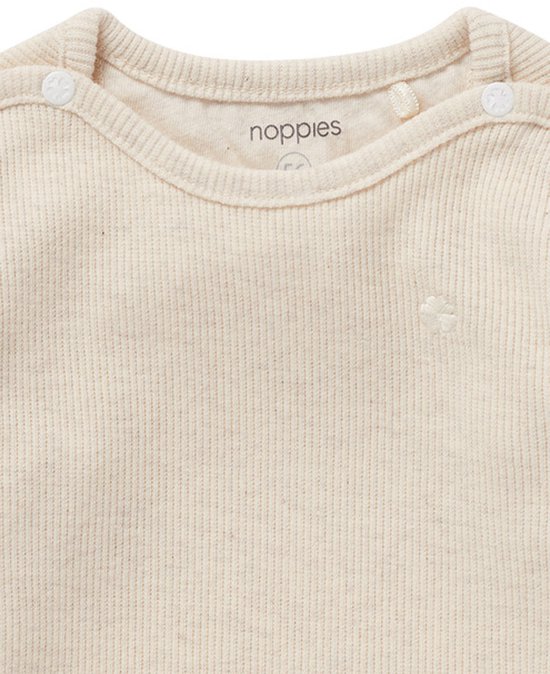 Detail van een crèmekleurig ribgebreid T-shirt met drukknoopjes en Noppies logo.