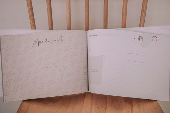 Open boek met beige patronen en tekst 'Mijn Kleuter'$. Rechts een blanco pagina met lijntjes en een vak voor een foto.