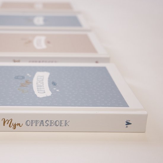 Meerdere 'Mijn Oppasboek' boeken op een rij, in pastelblauw en roze, met kleine driehoekjes en sterretjes.