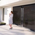 Vrouw met mok op terras bij glazen schuifpui met privacy folie.