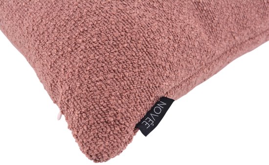 Detail van een roze bouclé kussenhoes met het NOVÉE label.