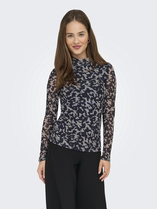 Vrouw in een nauwsluitend, langere mouwen shirt met een hoge nek en een abstracte print in donkerblauw en lichtgrijs. Ze draagt een zwarte broek.