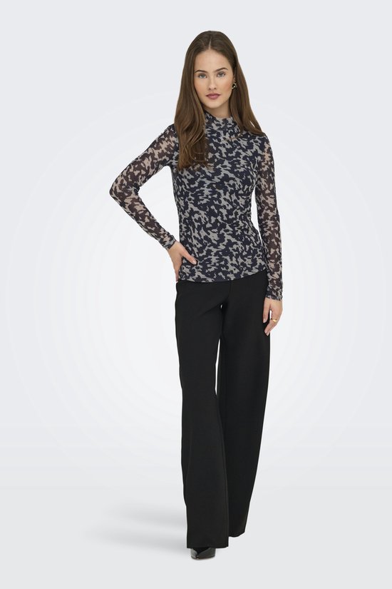 Model draagt longsleeve met hoge hals en abstracte print in nachtblauw en beige, met zwarte broek.