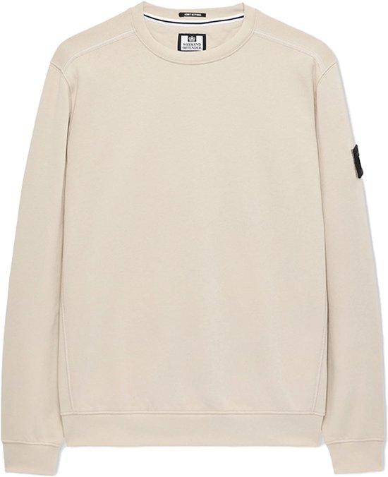 Een beige ronde hals trui met een klein label op de borst, met witte naden langs de zijkanten.