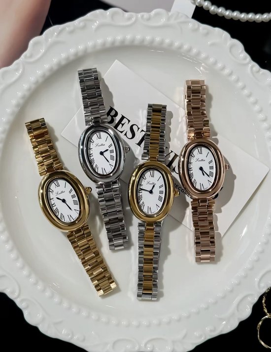 Vier dameshorloges met ovale wijzerplaten op een witte schaal, in zilver, goud en rosé goud.