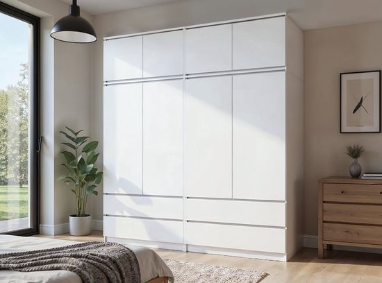 Brede witte kledingkast met vier deuren boven vier lades, in een slaapkamer.