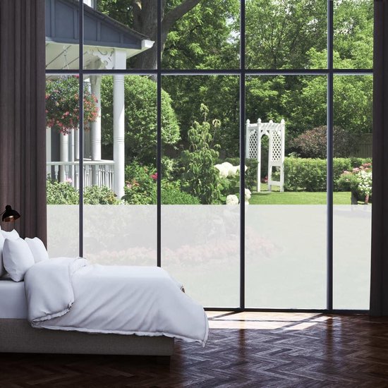 Slaapkamer met een raam dat uitkijkt op een tuin, de onderste helft van het raam is mat.