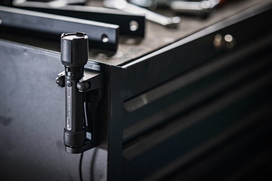 Zwarte Ledlenser P7R PRO zaklamp bevestigd aan een metalen rand.