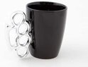 Tasse noire avec une poignée chromée en forme de poing américain.