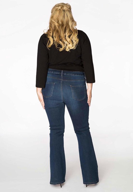 Vrouw met blond haar, achterkant, draagt een zwarte top en donkerblauwe spijkerbroek.