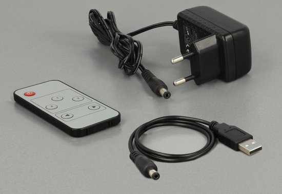 Zwarte afstandsbediening, stroomadapter met Europese stekker en USB-naar-DC-kabel op grijze achtergrond.