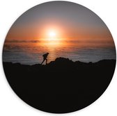 WallClassics - Dibond Muurcirkel - Man lopend over Berg aan de Zee met Zonsondergang - 100x100 cm Foto op Aluminium Muurcirkel (met ophangsysteem)