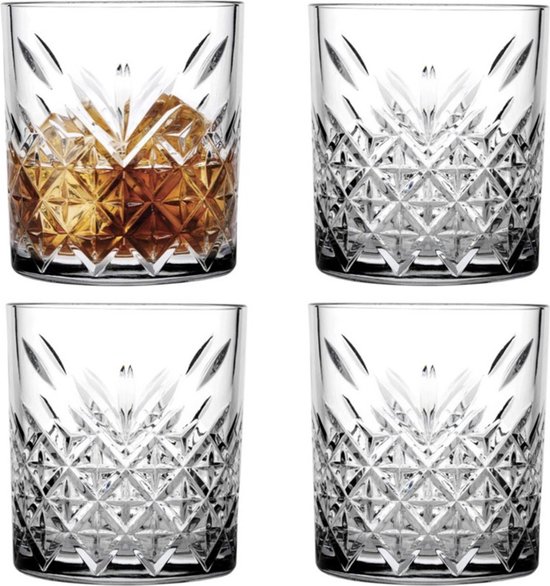 Quatre tumblers transparents avec verre taillé à facettes, l'un rempli de liqueur ambrée et de glaçons.