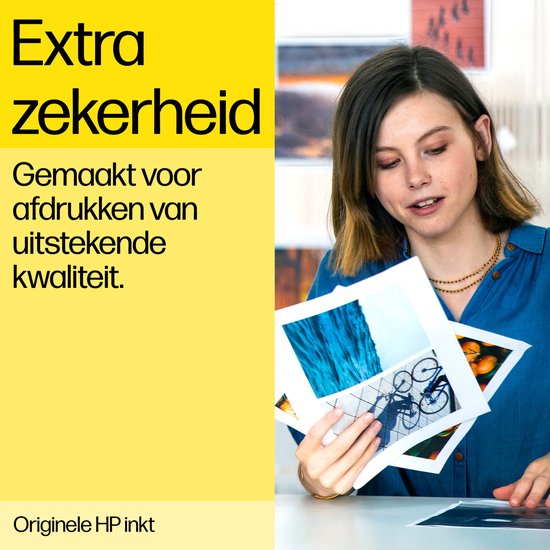Jonge vrouw met gouden ketting kijkt naar foto's in haar handen.