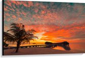 Canvas - Zonsondergang op het Strand met Palmbomen en Paalwoningen - 120x80 cm Foto op Canvas Schilderij (Wanddecoratie op Canvas)