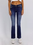 Model draagt donkerblauwe LTB Jeans Fallon flared jeans met lichte wassing en witte sneakers.