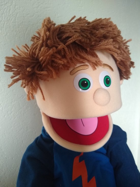Handpop Tommie met warrig bruin haar, grote groene ogen en een open mond met roze tong.