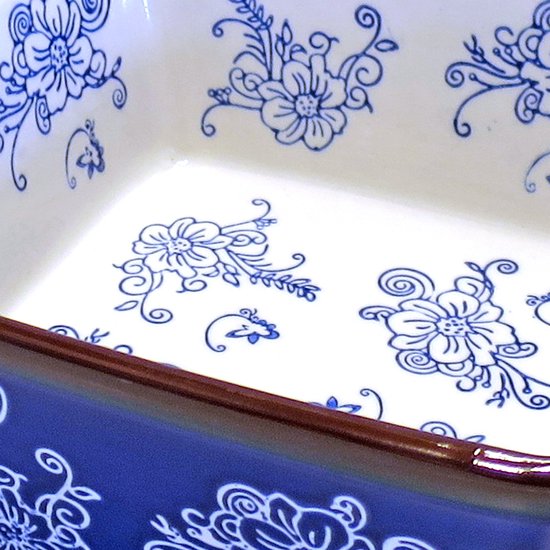 Detail van een witte vierkante ovenschaal met blauwe bloemenprint.