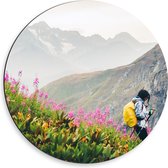 Dibond Muurcirkel - Hiker in Berglandschap met Roze Bloemenveld - 50x50 cm Foto op Aluminium Muurcirkel (met ophangsysteem)