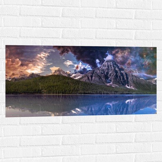 WallClassics - Muursticker - Heelal boven Bos op Bergen bij Rotsen aan het Water - 100x50 cm Foto op Muursticker