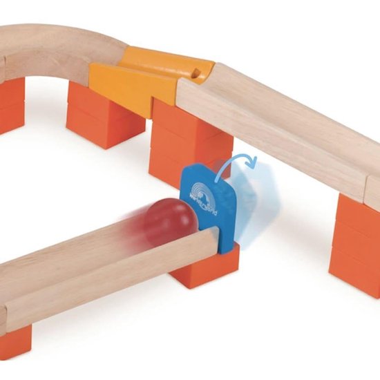 Een close-up van een rode bal die over een houten knikkerbaan rolt, langs een blauw "Wonderworld" stopbord.
