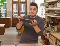 Jeroen Meus houdt een groene koekenpan met RVS handgreep omhoog in een keuken.