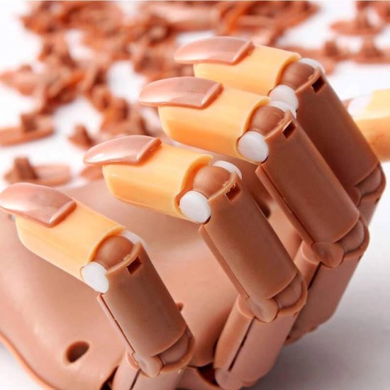 Gros plan de la main d'entraînement brune avec des faux ongles aux détails orange et blancs.