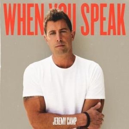 Jeremy Camp met armen over elkaar, draagt een witte t-shirt. Tekst: 'WHEN YOU SPEAK'