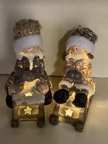 Kerstbeeldjes jongen en meisje op slee met LED - Taupe - 15 cm hoog x 11 cm x 5cm – Kerstdecoratie