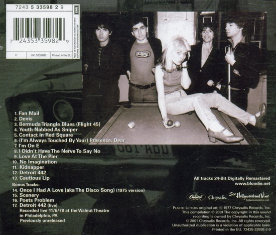 Een groep van vijf personen, waaronder zangeres Debbie Harry, poseert op en rond een biljarttafel.