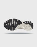 Onderkant van de beige en zwarte Saucony Guide 7 zool met profiel.