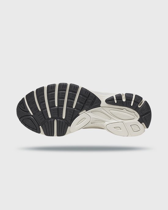 Onderkant van de beige en zwarte Saucony Guide 7 zool met profiel.